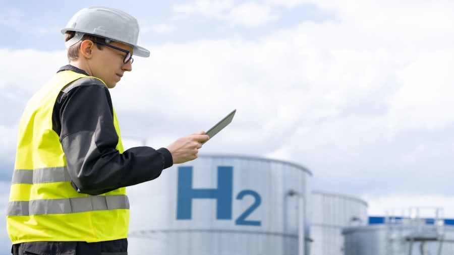 Engineer using digital tools to monitor hydrogen storage tanks, highlighting safety and simulation in hydrogen infrastructure.