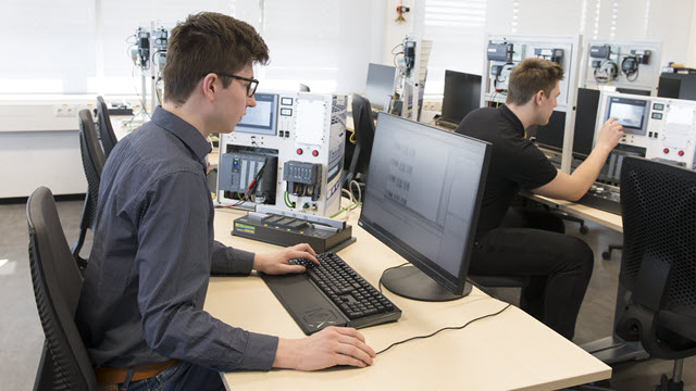 Two engineers in an office, each are working on their desktop