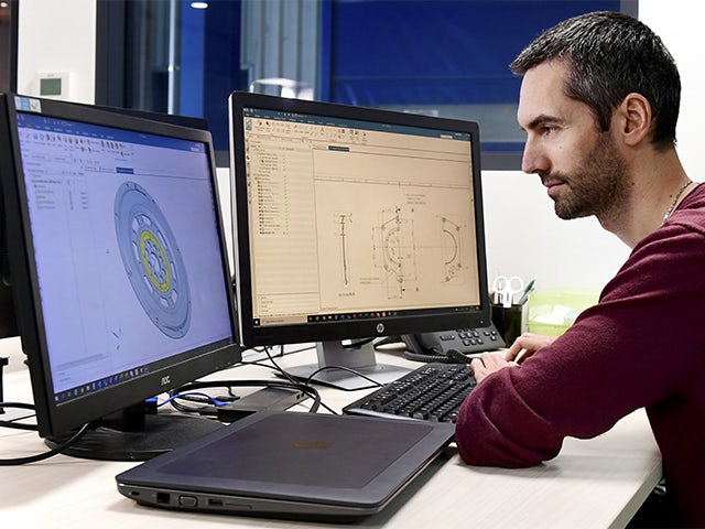 An engineer using Simcenter simulation software.