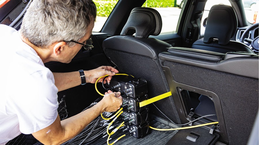 Test engineer instrumenting vehicle for in-field data acquisition using Simcenter SCADAS RS