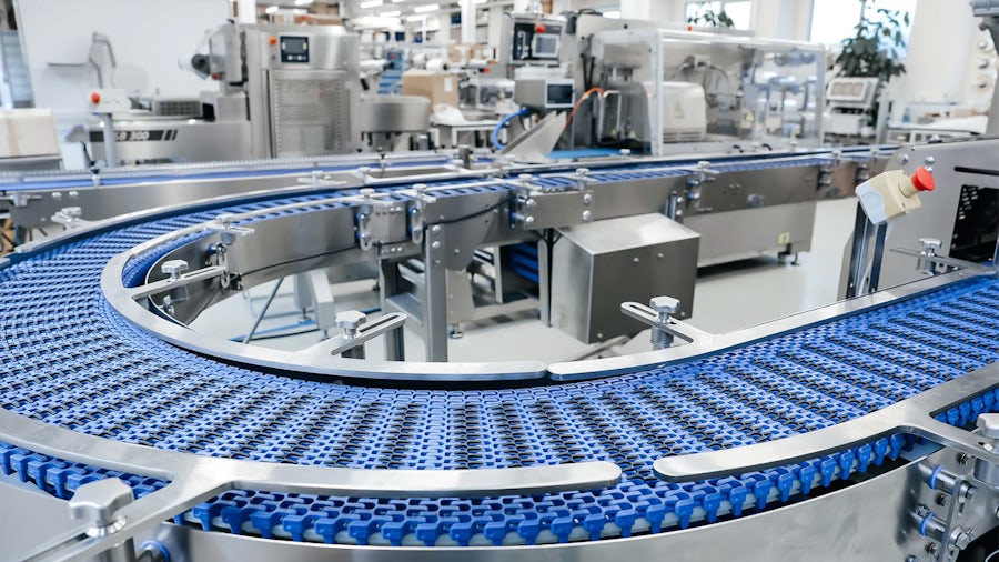 A blue industrial conveyor belt in a configure-to-order manufacturing facility.