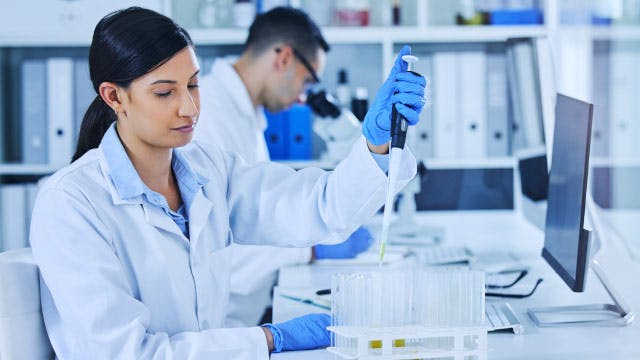 Woman and man wearing lab coats working in a lab