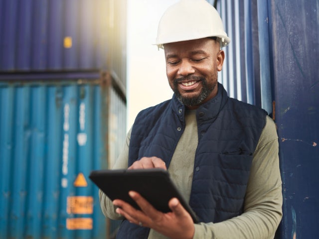 Un ouvrier du chantier naval regarde une tablette.