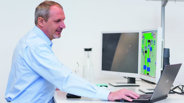 Man working at workstation with 3 monitors