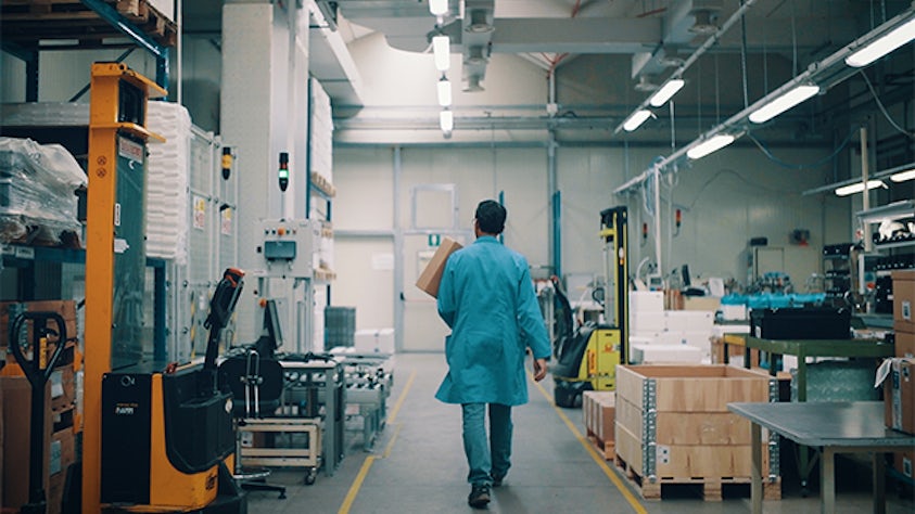 An intraplant logistics warehouse manager walking around a warehouse.