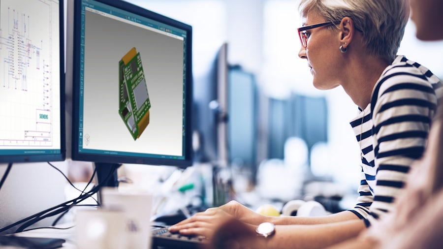 An engineer looking at two monitors showing Xpedition Standard software.