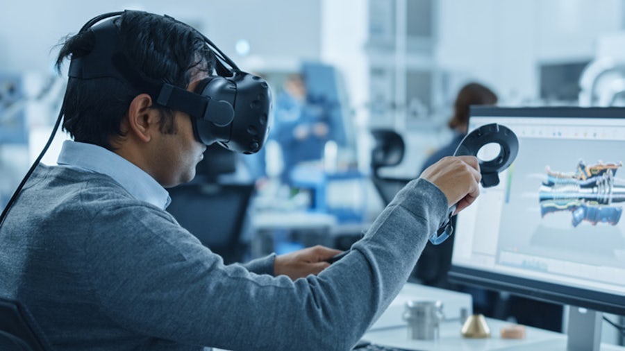 An engineer uses a virtual reality headset to make design changes to a machine component.