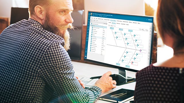 Professionals analyzing closed-loop quality improvement process on computer screen with workflow diagrams.