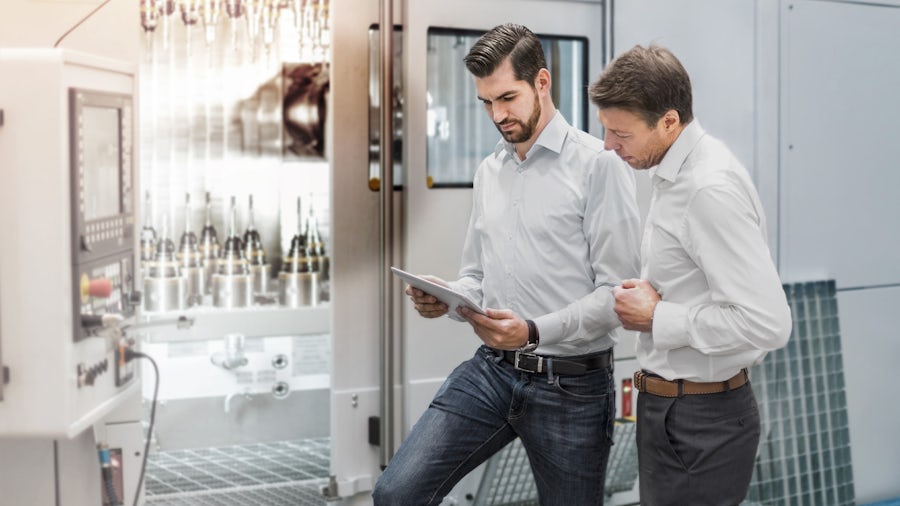 two men looking at a tablet