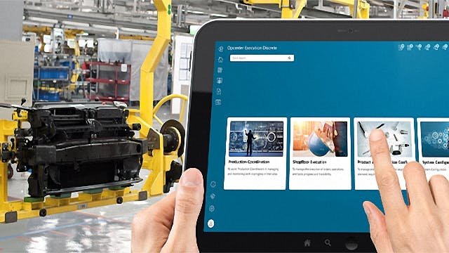 A person holds a tablet to collect and view manufacturing analytics using sensors and IIoT
