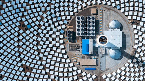 Eine von Sonnenkollektoren umgebene Industrieanlage verwendet eine Software für das Energiemanagement, um die betriebliche Effizienz zu maximieren.