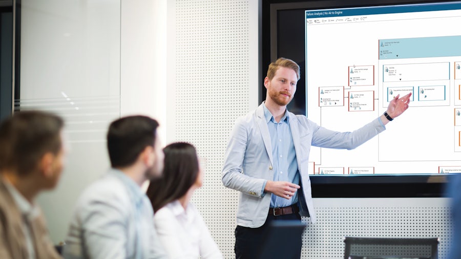 Engineers working on quality management systems in a factory