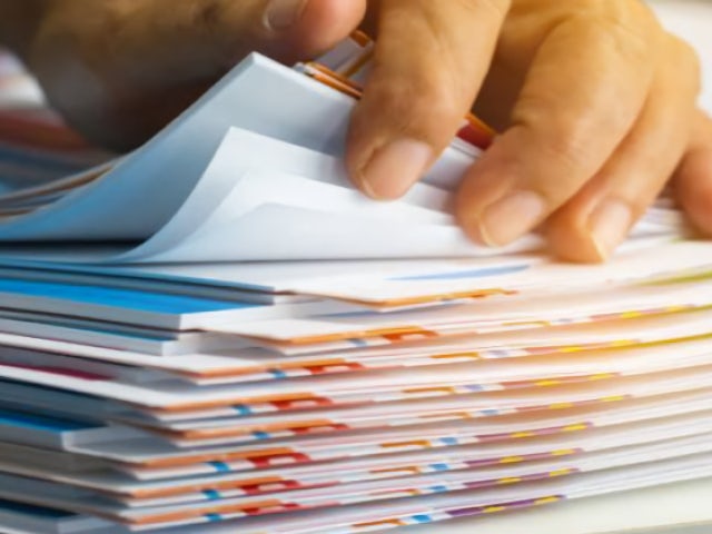 A person fingering through a stack of documents.