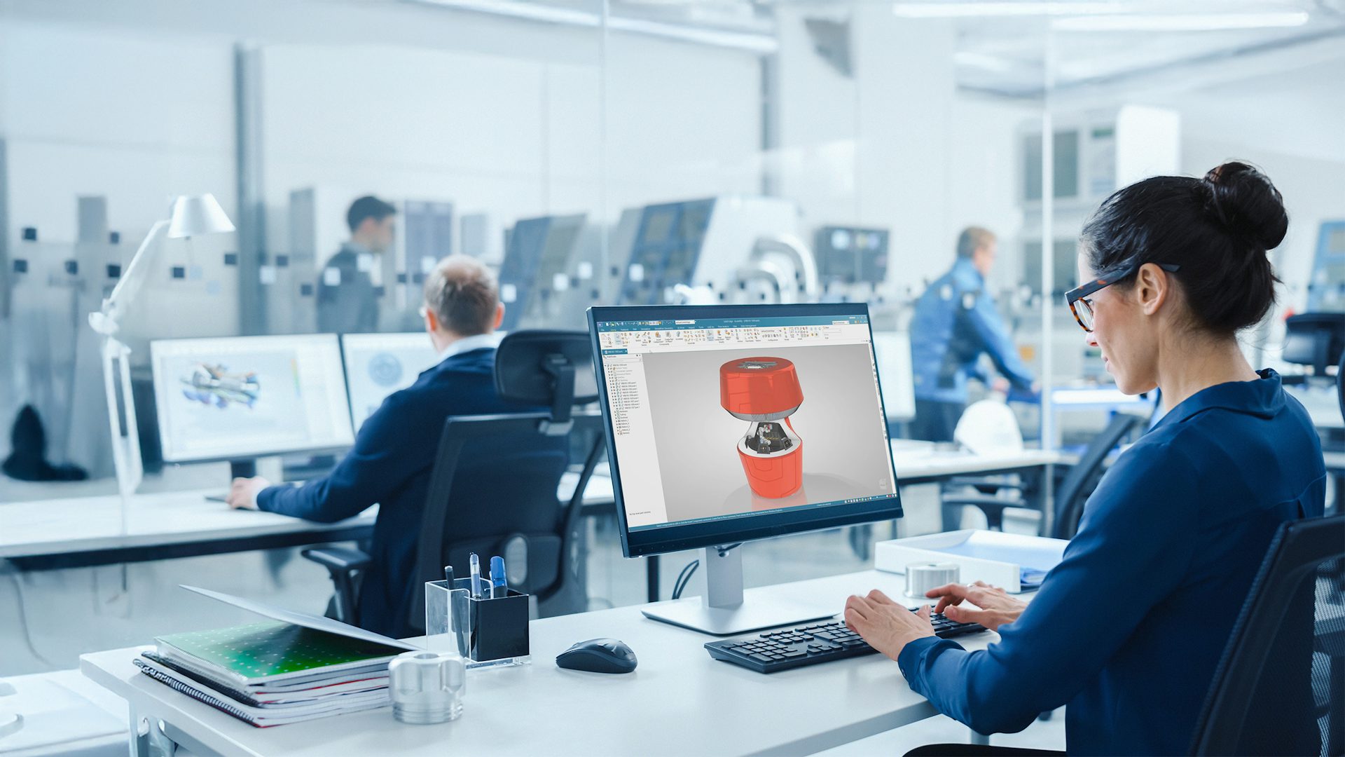 Woman sitting in front of a computer editing a robot bar tender 3D model in Solid Edge.