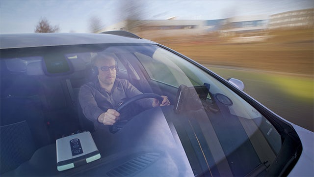 An engineer driving a car while running an NVH operational testing.
