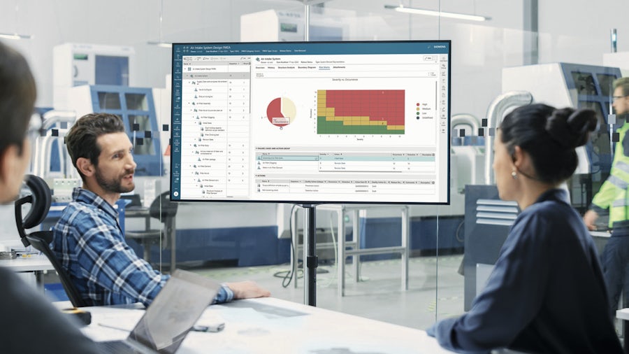 Workers looking at a screen showing closed-loop quality data from Teamcenter Quality