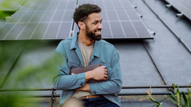 higher education student in front of solar panels