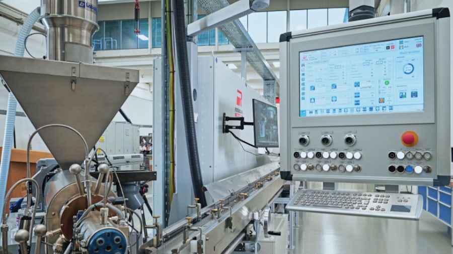 A machine in a factory setting, featuring a monitor and additional equipment.