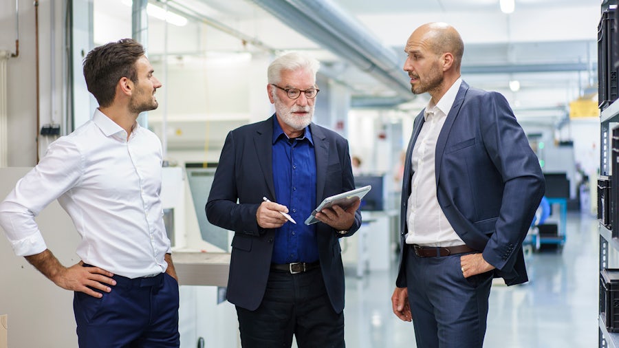 Three quality professionals discussing QMS best practices