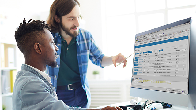 Two engineers are using Questa Verify Trust on a desktop