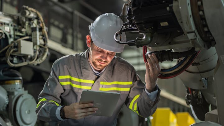 製造施設でサービス文書作成ソフトウェアを使って作業するエンジニア。