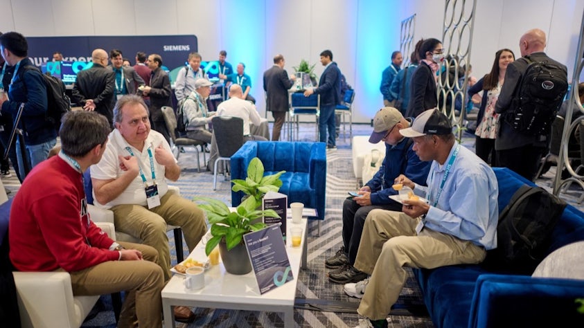 A group of User2User event attendees in a discussion at a reception.