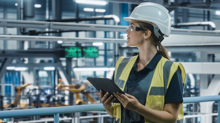 Women working in a factory and holding a clipboard 