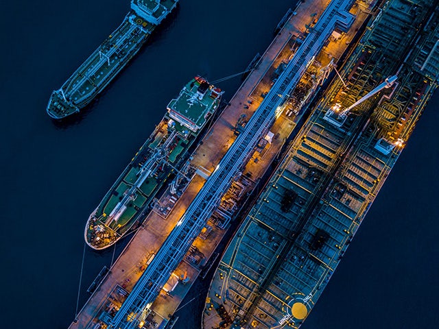 An evening, aerial view of multiple container ships at a port.