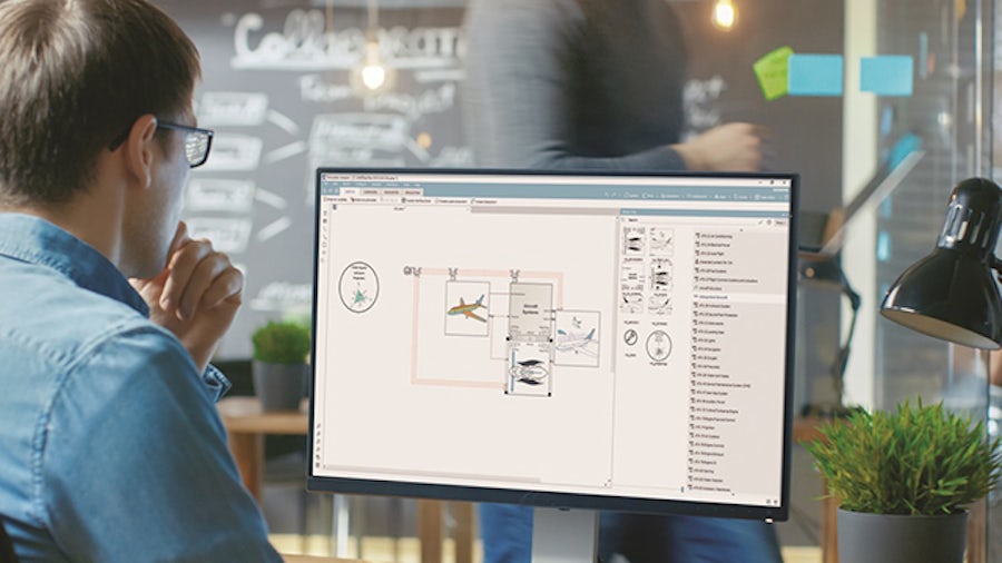 Image of an engineer in front of a computer screen assessing systems interactions at early design stages to accelerate aircraft systems engineering