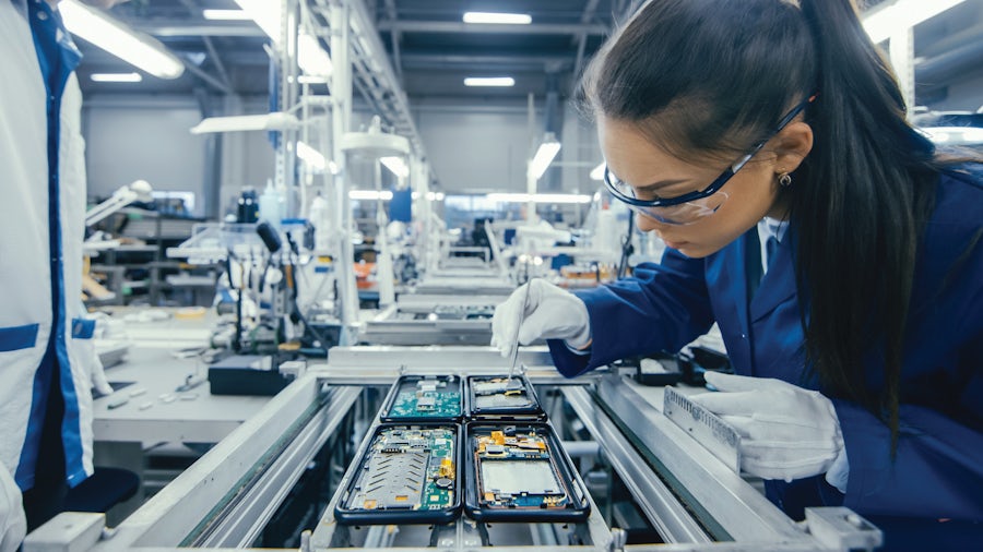 Women with safety glasses working on a printed circuit board - PCB