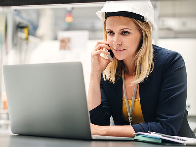 Factory manager reviewing plan schedule with her team