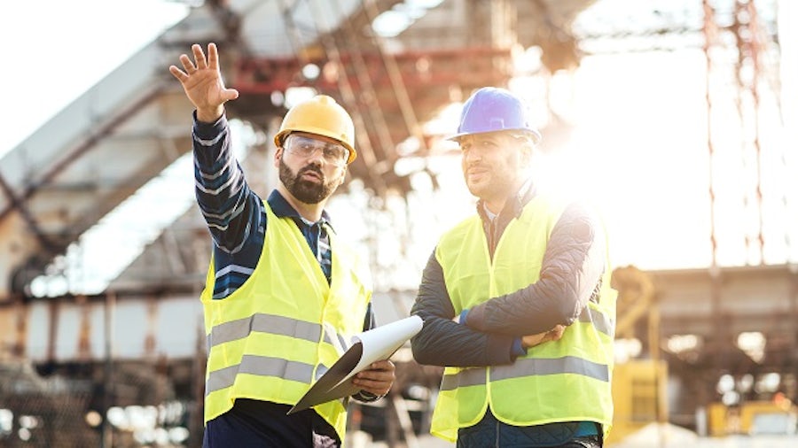 Due operai edili che guardano il progetto
