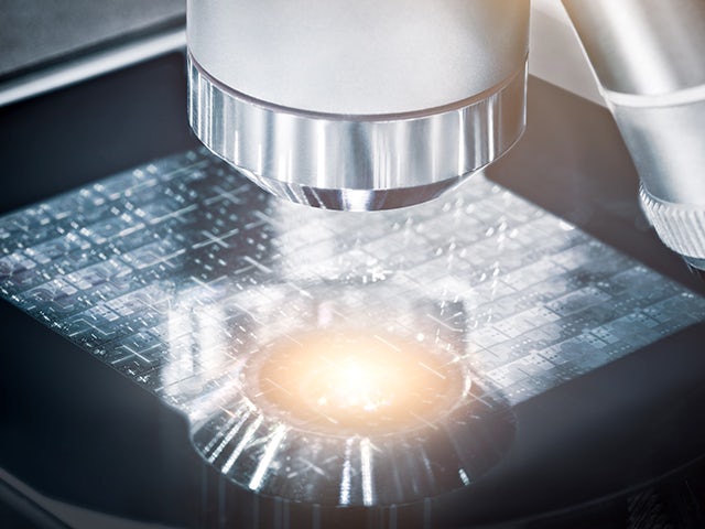 Microscope examining IC wafer | Tessent YieldInsight identifies the cause of systematic yield loss and provides guidance through the process of selecting die for failure analysis. 