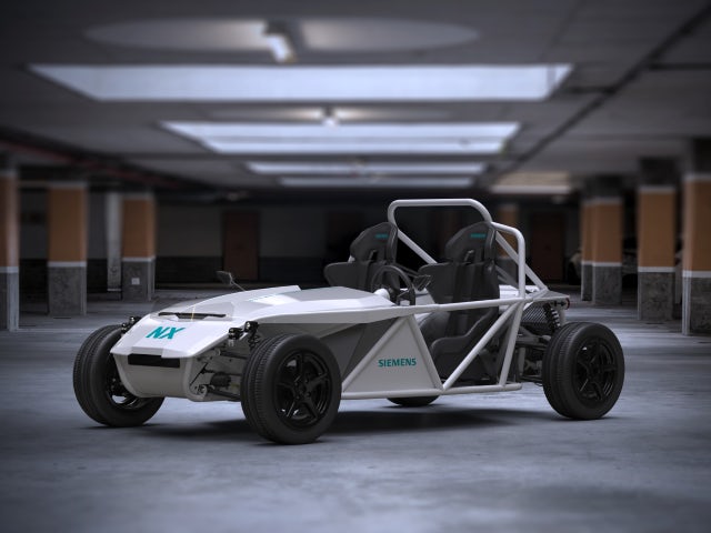 A white electrical vehicle designed in NX in a garage, the car has "Siemens" and "NX" printed on it