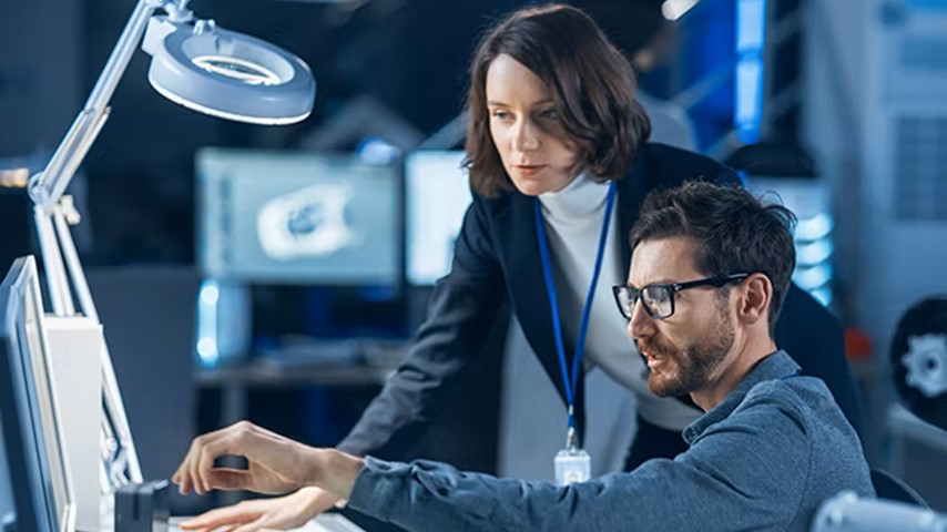  A collaborative engineering or technical design environment where a woman and a man are engaged in a focused discussion while working on a compute