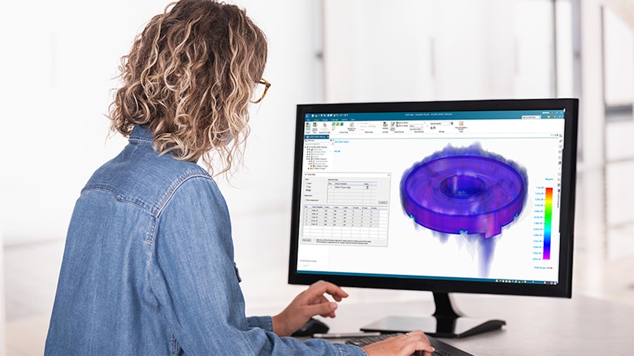 Worker at workstation running Solid Edge simulation in an office environment to perform quality inspection.