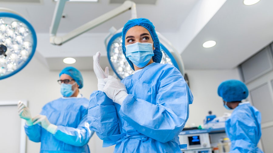 A hospital operation room with three doctors wearing medical scrubs. 