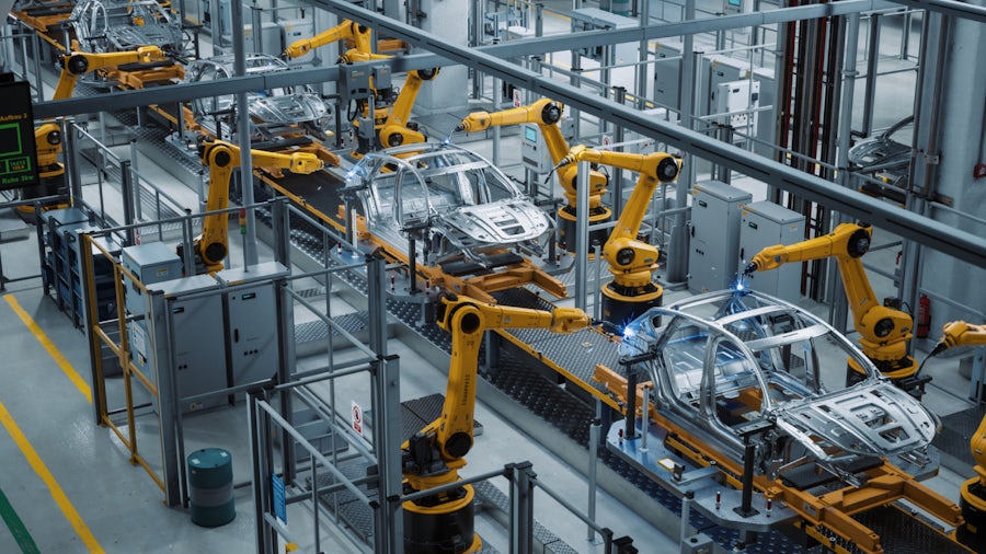 A car factory 3D concept showing an automated robot arm assembly line manufacturing.