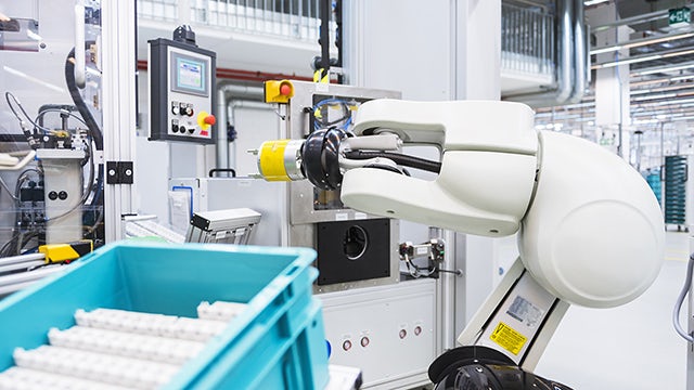 A robot performing tasks in a manufacturing facility.