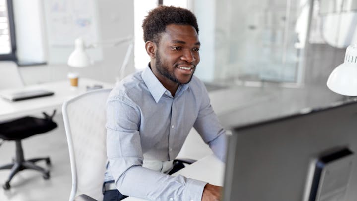 사무실에서 컴퓨터로 작업하고 있는 남자.