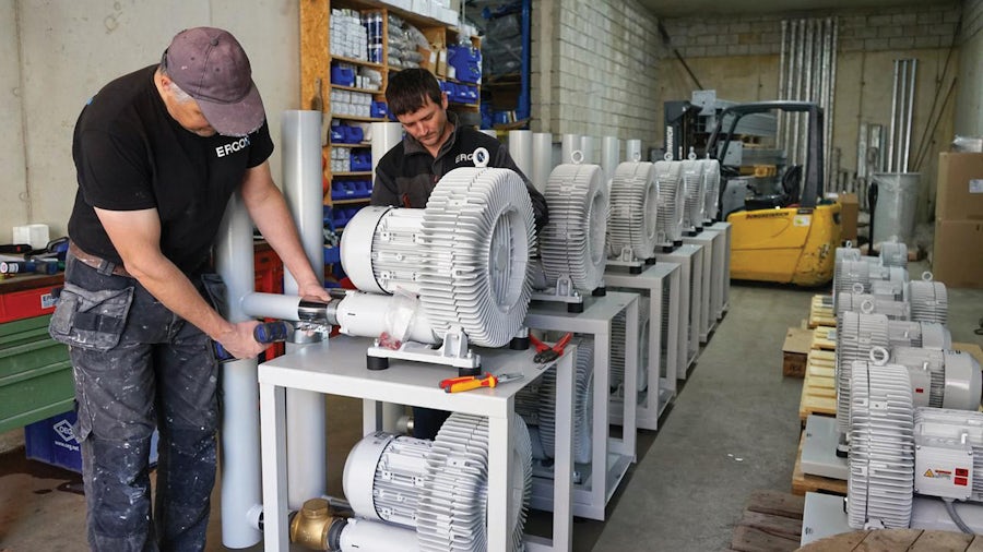 Due ingegneri testano più componenti dei macchinari industriali con configurazioni diverse.