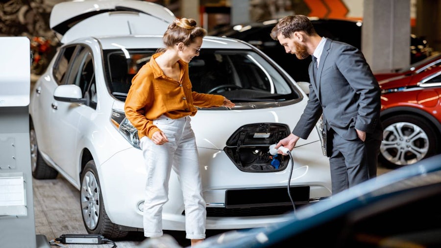 Salesperson showing customer a sustainable electric vehicle. 