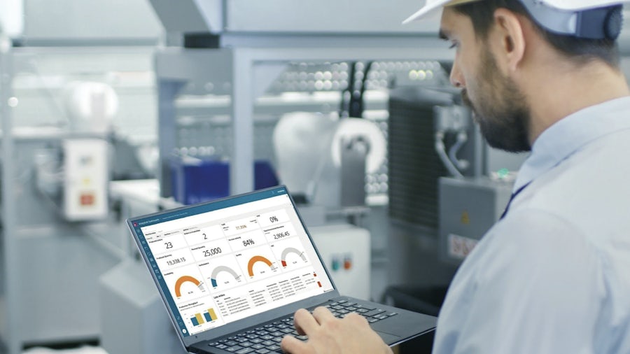 Worker using Opcenter Intelligence Cloud, an enterprise software-as-a-service (SaaS) solution for manufacturing data analytics.