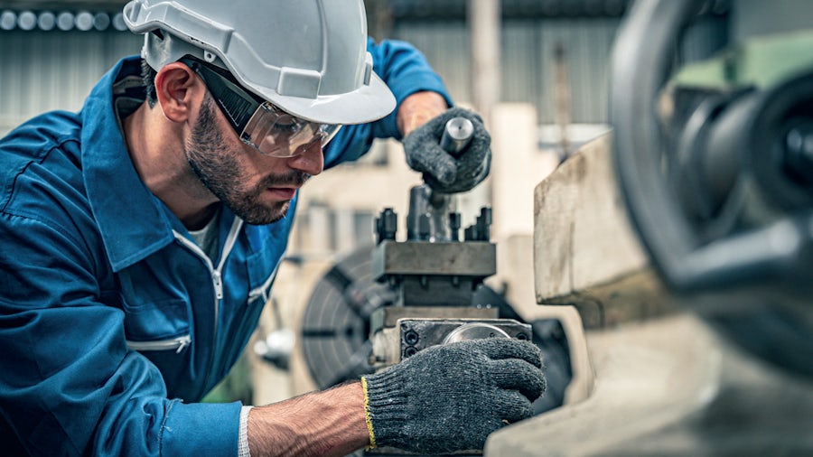 Production manager working inside a smart manufacturing heavy equipment facility