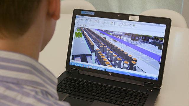 Electrolux engineer working with Plant Simulation software on a laptop computer.