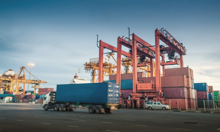 Airplane flying over container port
