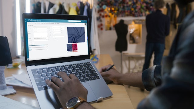 Person on laptop using fashion PLM