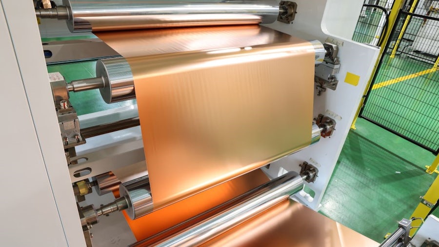 A factory machine covered in copper foil, used for processing battery materials.