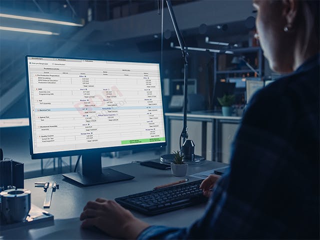 Worker looking a a screen showing the Process Preparaton X BOM Connector Assembly Addon that includes a cost calculator to price different production scenarios, labor rates, and other variables