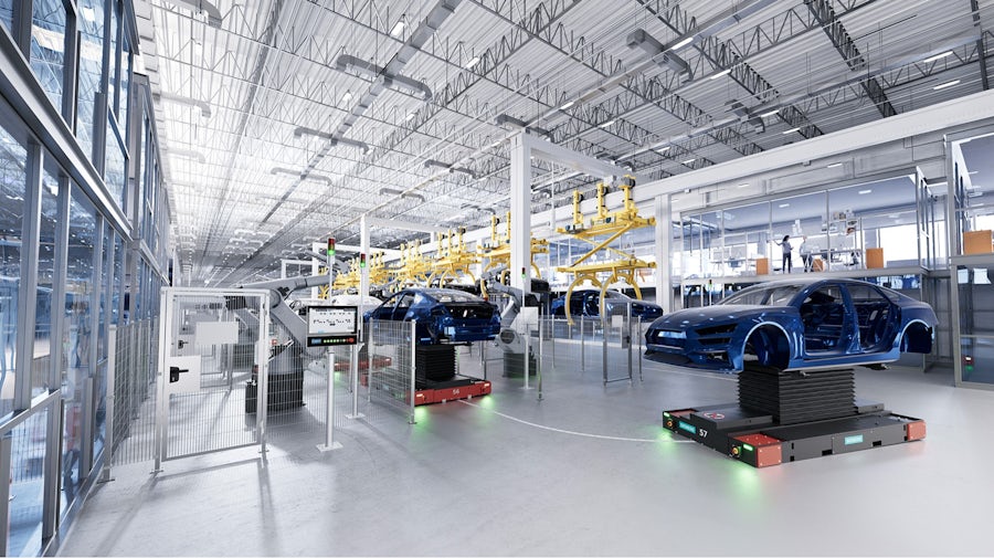 Automotive engineer using a digital tablet to monitor robotic assembly with AI analytics in an automotive factory.